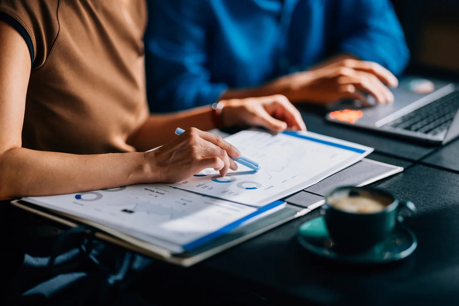 Reunião de gestão preventiva analisando relatórios financeiros e indicadores do condomínio